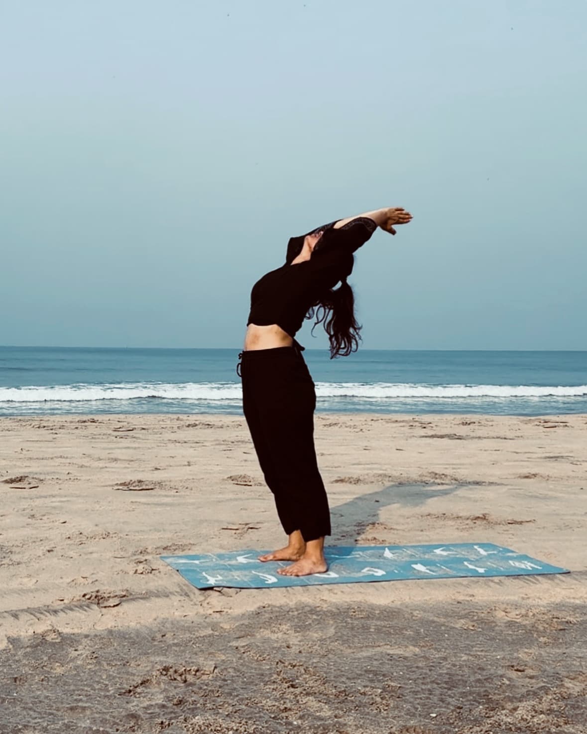 Nikita Sharda practising a backbend on a beach