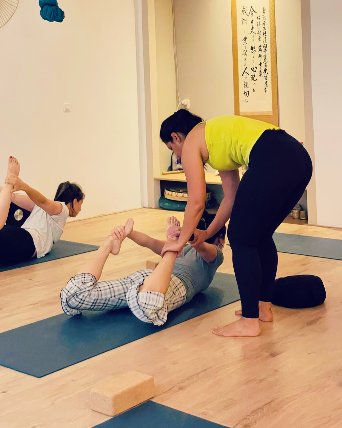 Nikita Sharda adjusting a student during a yoga class